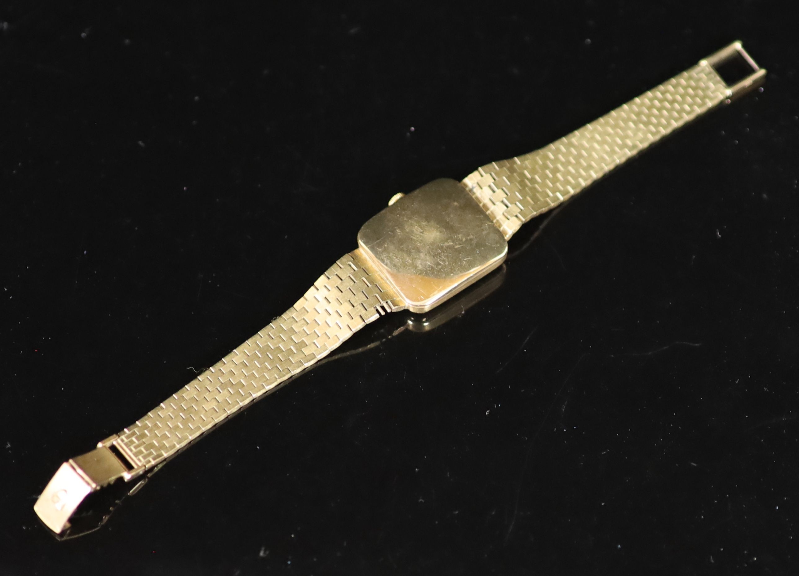 A lady's 1980's 9ct gold Tudor manual wind rectangular dial wrist watch, on an integral 9ct gold brick link bracelet